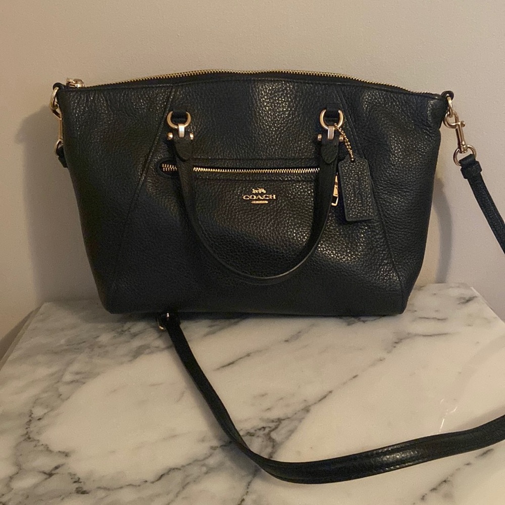 Black pebble leather coach satchel with shoulder strap.